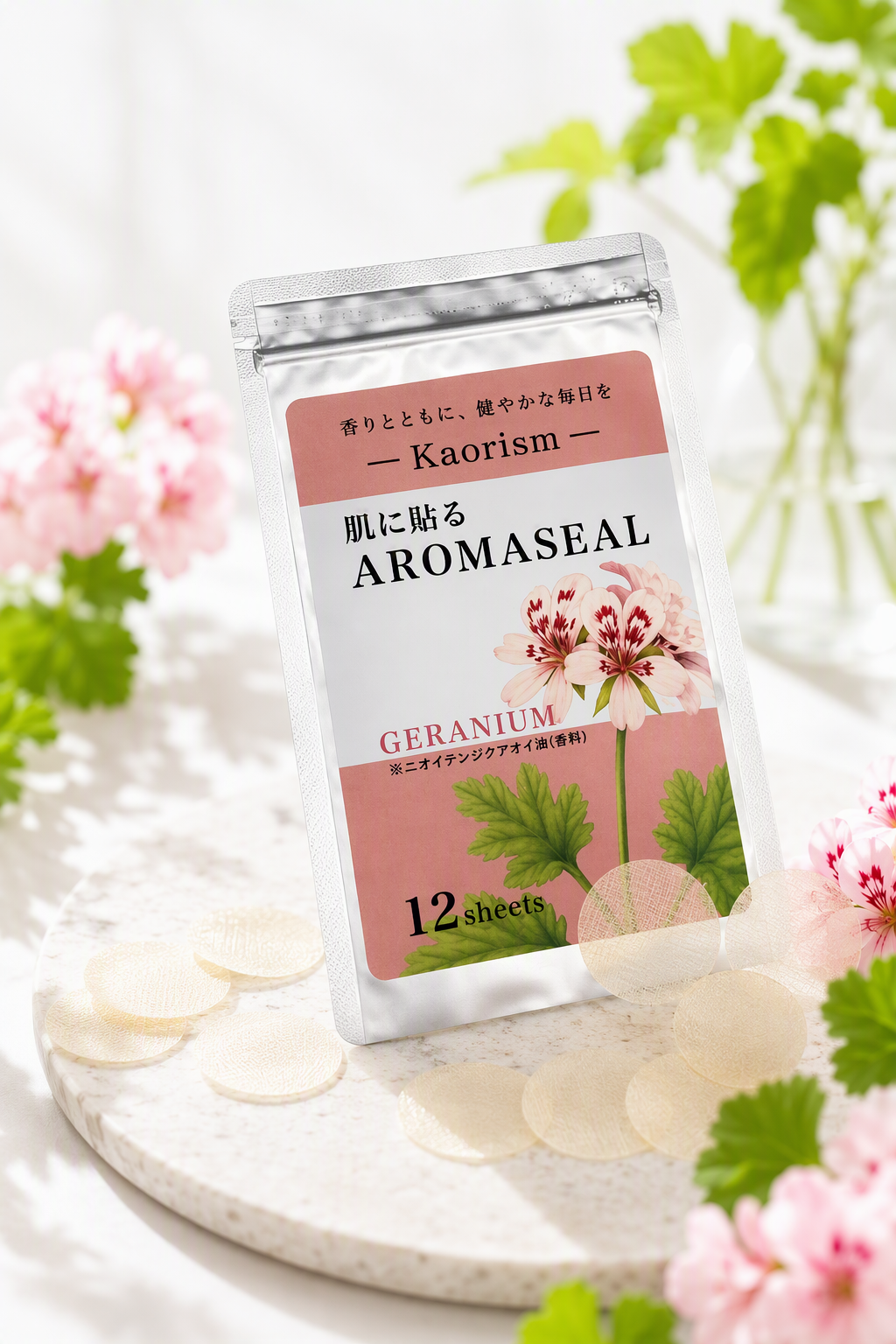 ゼラニウムの花に囲まれた、肌に貼るAROMASEALのパッケージとシール